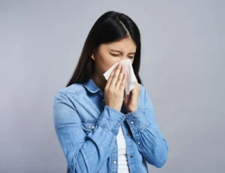 Girl sneezing indoors due to mold allergies